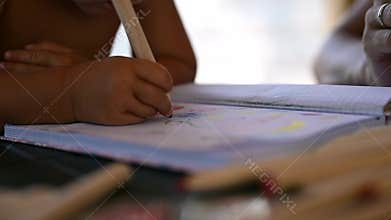 Toddler girl coloring and drawing in her noteboook