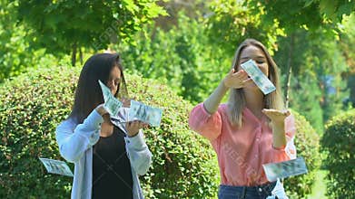 Extremely happy female friends rejoicing lottery cash prize, throwing money up