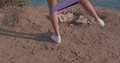 Woman exercising on sea shore cliff at sunrise
