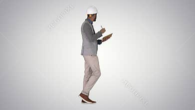 Arabic man in casual clothes and hard hat writing down checklist on gradient background.