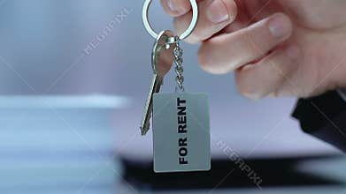 Real estate agent holding for rent key, rental service, accommodation business