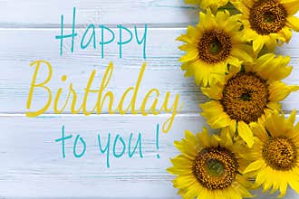 Happy Birthday. Greeting card with flowers for a girl, mom`s birthday. View from above. Sunflower flowers on a light wooden