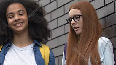 Biracial teen girl pushing classmate to wall, outcast in high school, bullying