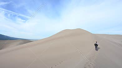Backpacking woman hikes away from camera