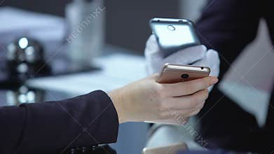 Hotel receptionist scanning QR code on lady smartphone, new payment technologies