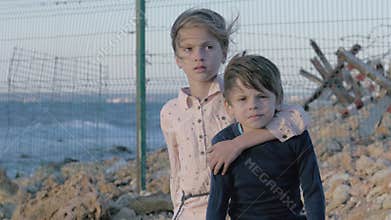 Portrait two abandoned children near border between countries. destroyed family a consequence of the war. helpless little boy and