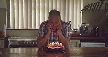 Senior man with a birthday cake at home