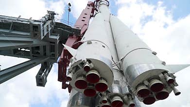 View of bottom of rocket on background of sky. Action. Realistic monument of white Vostok rocket with nozzles towering