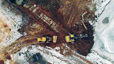 Heavy machinery at a construction site. Industrial tractors, excavators work at a career with sand.