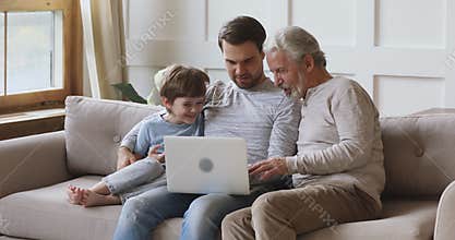 Friendly three age multi generation men family using laptop together