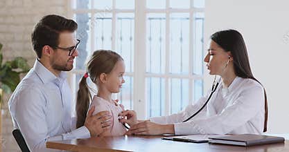 Happy child patient and paediatrician give high five after checkup