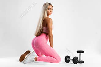 Fitness woman in leggings on gray background. Athletic girl with beautiful butt