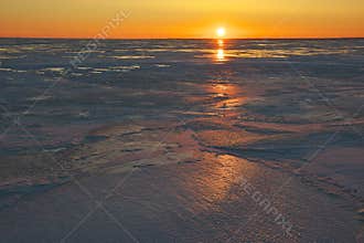 Frozen sea colored in vivid colors of sunset