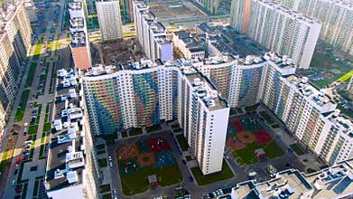 Aerial view of the multi-storey buildings, block of flats, playgrounds inside the yard. Motion. Flying above the new