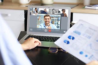 Business woman talking to her colleagues in video conference. Business team working from home using laptop