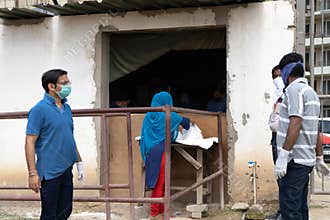 People in masks serving food to underprivileged people like maids, drivers, house cleaners etc during the coronavirus
