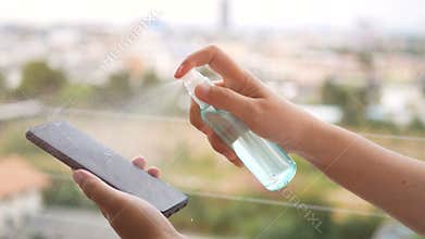 Disinfect, sanitize, hygiene care. inject alcohol spray on mobile phone, frequently touched area for cleaning and disinfection