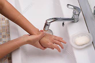 The girl brought the burn place under a stream of water for first aid