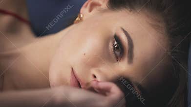 Blur effect portrait closeup woman lying touch face hand makeup eyes fluffy long eyelashes iris pure skin passion sensual lips rom