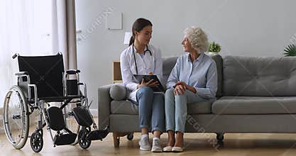 Pleasant nurse asking questions about health condition to patient.