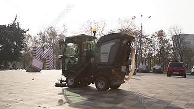 March, 12, 2020 - Mariupol, Ukraine. Street sweeper car cleaning city sidewalk paving slabs with pressure washers and