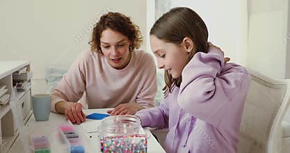 Teenage daughter and mom playing mosaic game at home table