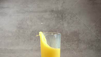 Ice Cubes Fall in Orange Juice. Slow Motion