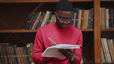 Standing student in library studying for exam