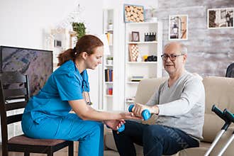 Female nurse doing physiotherapy with senior man