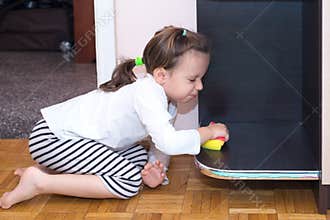 Little girl cleaning and disinfecting the furniture