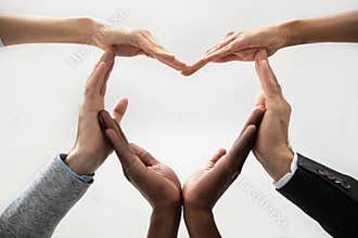 Concept of diverse business people join hands forming heart.
