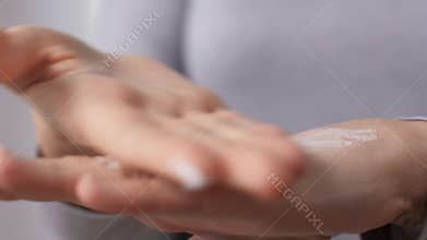 Close up of woman applying moisturizing hand cream
