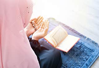 Muslim woman pray with beads and read quran