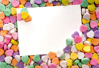 Blank note card surrounded, framed by candy hearts