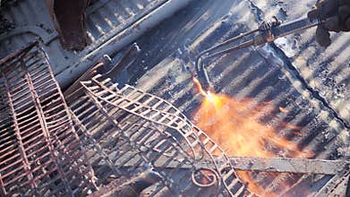 Cutting metal sheet at the scrap yard with oxygen cutter