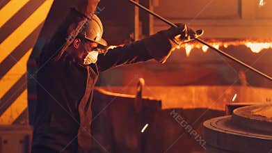 Young Man Working in a steel mill working in the hot manufacture