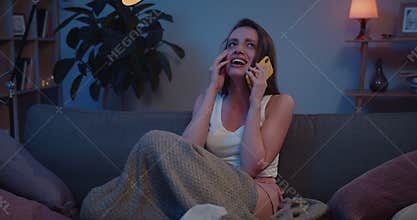 Front view of young sad girl talking on smartphone and weeping. Unhappy woman having unplasant emotional conversation on