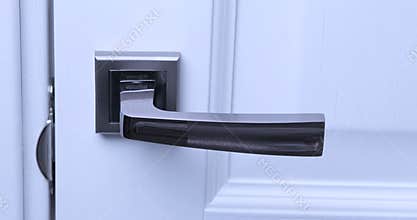 A man sanitizes a doorknob with a disinfectant wipe. COVID-19 pandemic of 2020