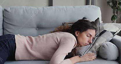 Exhausted or bored young sleepy woman falls down on sofa