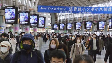 Large crowd group of Asian people walk at Shinagawa subway train station hallway in Tokyo Japan