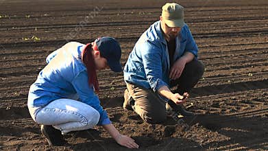 TWO YOUNG FARMERS ANALYZING THEIR LAND