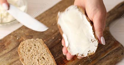 Spreading cheese or butter spread on bread.