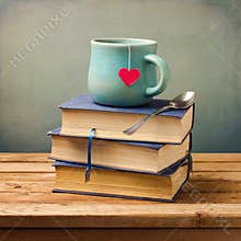 Old vintage books and cup with heart shape