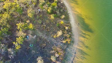 Curved shoreline and remote waterfront primitive camping sites with tents at Isle du Bois Ray Roberts Lake State Park lush green