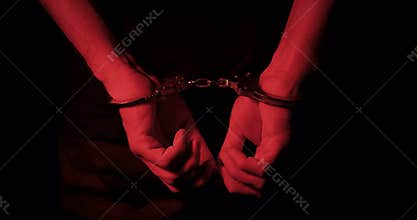 man handcuffed behind back by the police. beacon lights