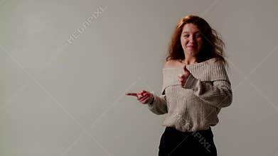 Curly red haired emotional girl pointing finger copy space and showing like thumb. Recommend mental health therapy