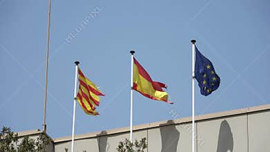 A Catalan flag flies in the wind against a blue sky