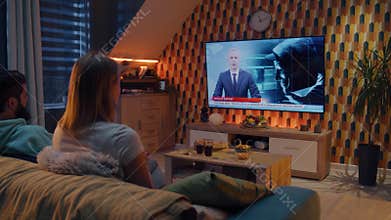 Couple watching TV news about hacker group