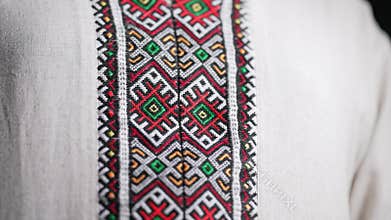 Man demonstrating geometric details of embroidery ornament on vyshyvanka shirt. National costume - embroidered shirt
