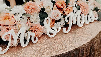 Closeup of the words "Mr. and Mrs." on a table with wedding flower arrangement
